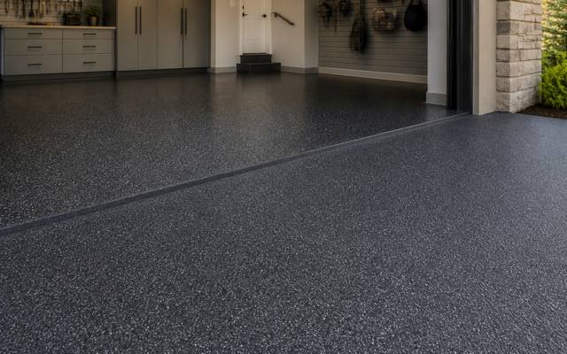 Two-car garage floor in dark speckled rubber surfacing after a one-day install.