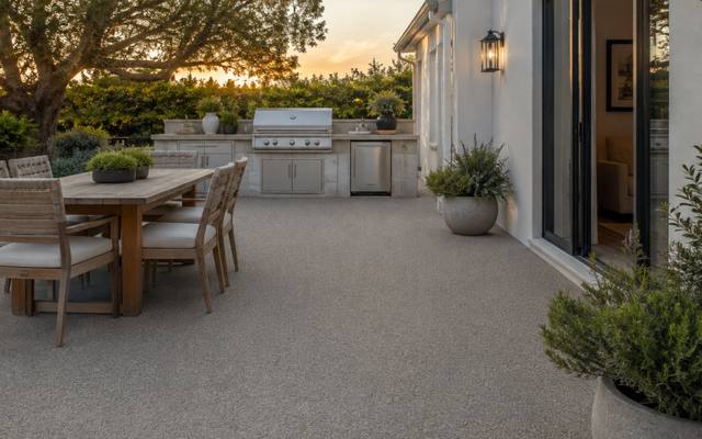 Outdoor kitchen and dining patio finished in tan rubber surfacing for an Oakville home.